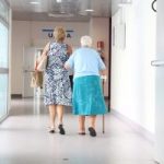 elderly woman and daughter walking down hall