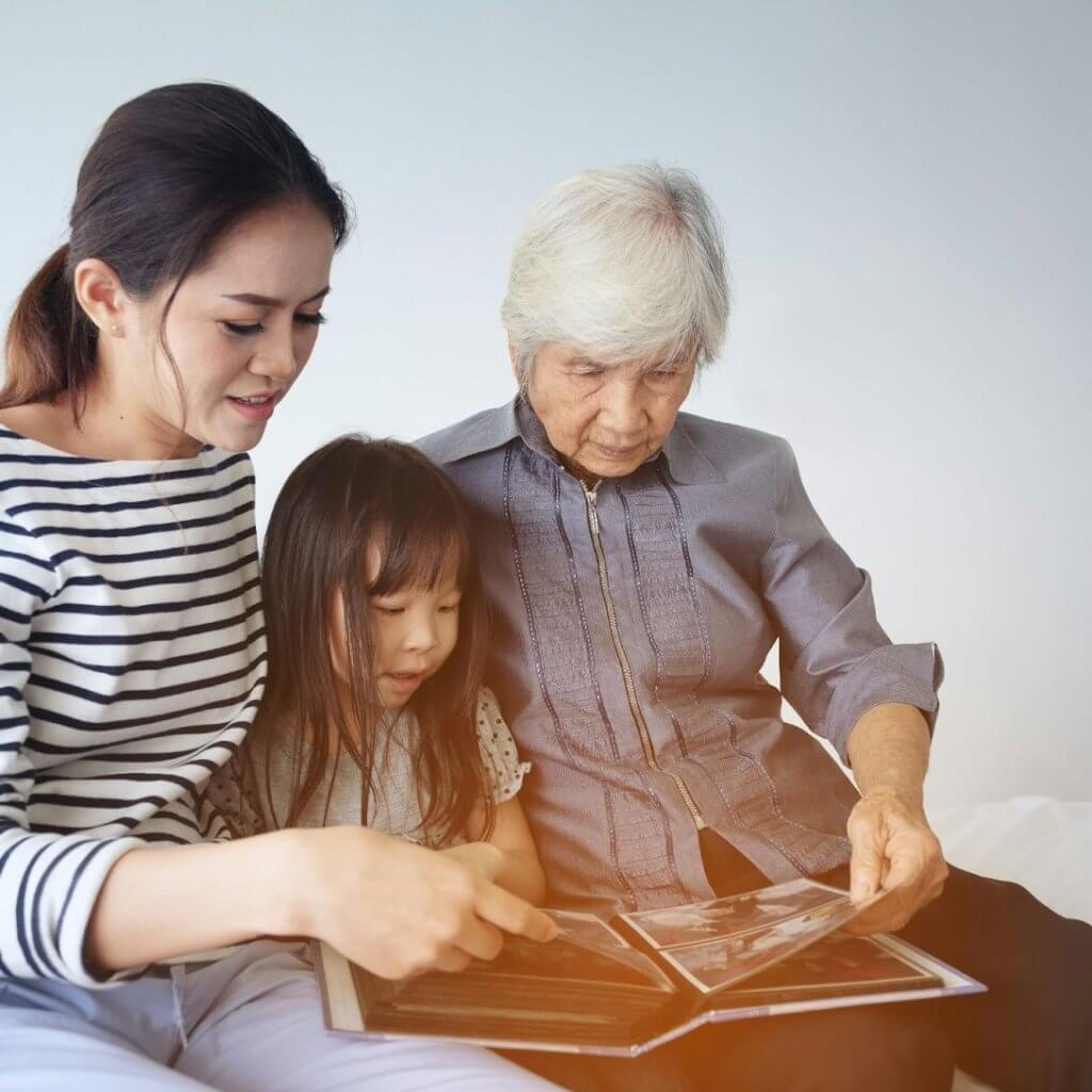 multigenerational family looking at a photo album