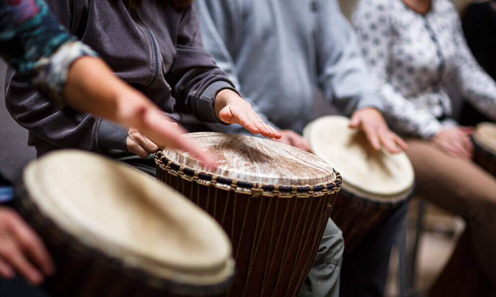 people playing drums as music therapy