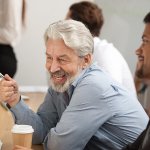 senior man looking at computer screen with coworker