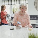 an elderly woman cleaning and doing housework
