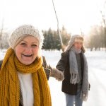 senior couple holding hands outside while iceskating